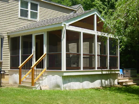 A tan clapboard house with a screened porch and timber steps
