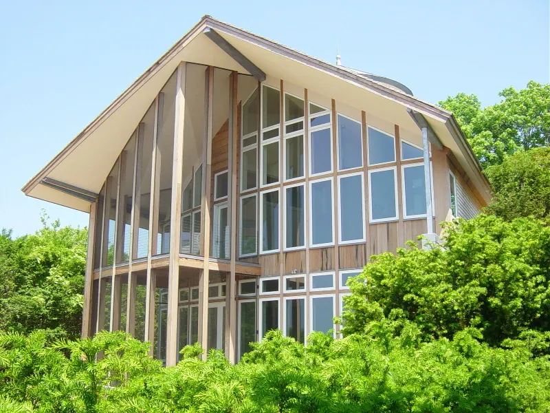 A gable-end sunroom with full-height glazed and screened panels in a timber frame