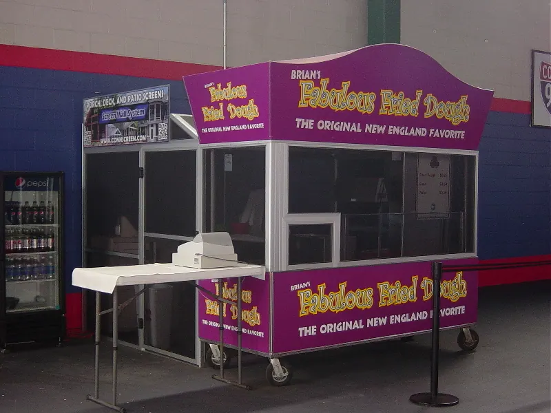 A fried dough concession trailer with its serving hatch fully screened
