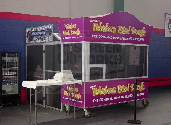 A fried dough concession trailer with its serving hatch fully screened